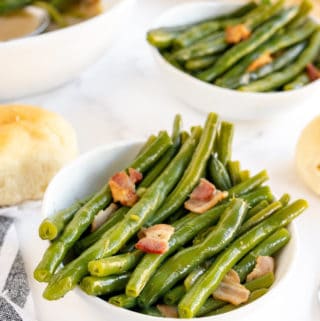 Close up of Southern Style Green Beans in white bowl showing bacon