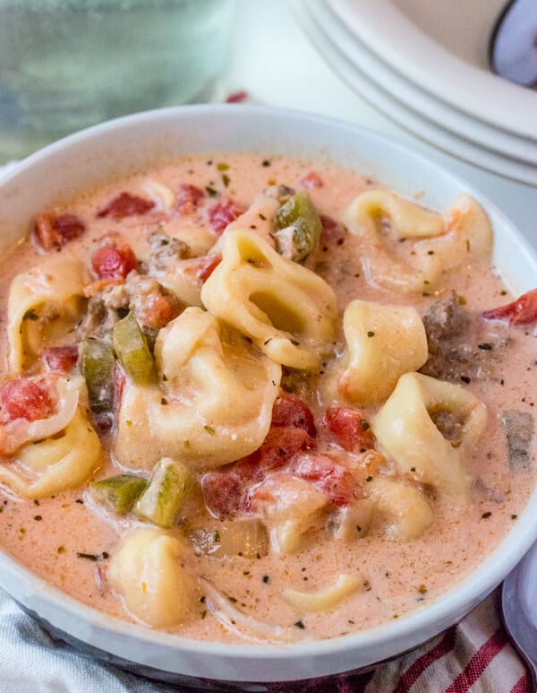 Bowl showing off peppers, tomatoes and tortellini in creamy sauce