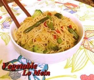 Lo mein i bowl topped with vegetables and chopsticks