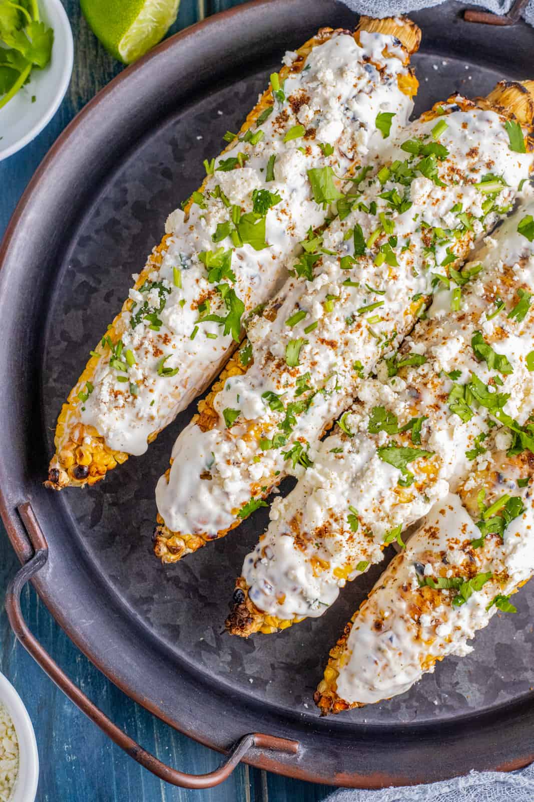 Overhead of finished corn on black platter topped with cilantro