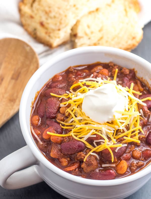 Finished Sweet Heat Chili in bowl garnished with cheese and sour cream