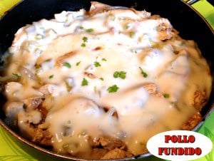 Pollo Fundido in large pan finished topped with melted cheese sauce and chopped cilantro