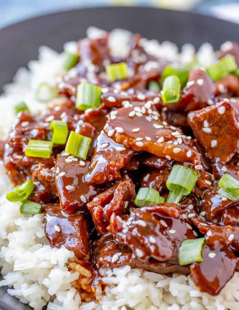 Plated Mongolian beef over rice on black plate