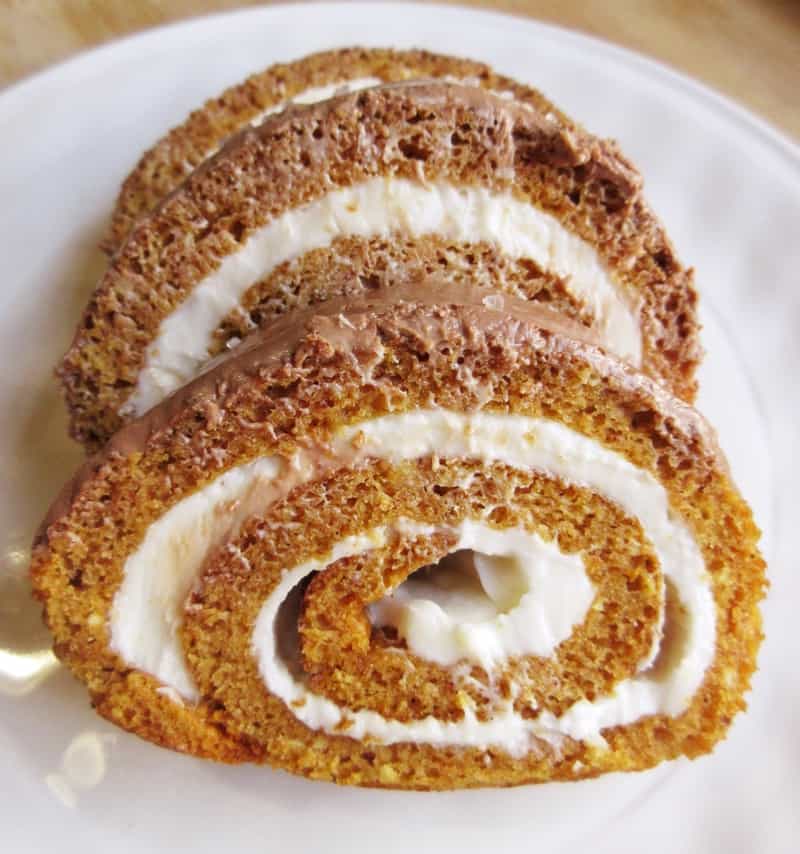 Three slices of the pumpkin roll on white plate