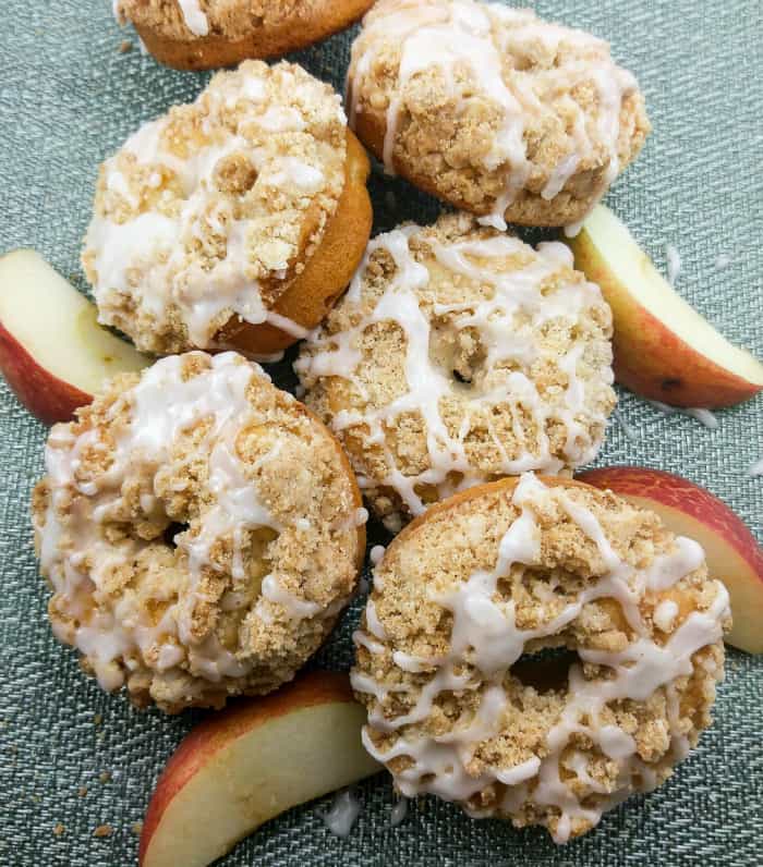 Stacked Apple Coffee Cake donuts glazed and surrounded by apples