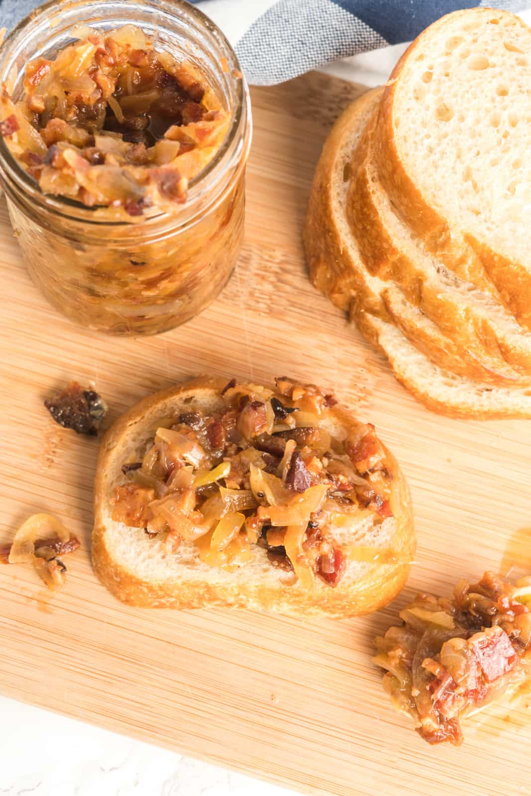 Overhead photo of Bacon jam spread onto piece of bread with spoon holding some jam on it's side