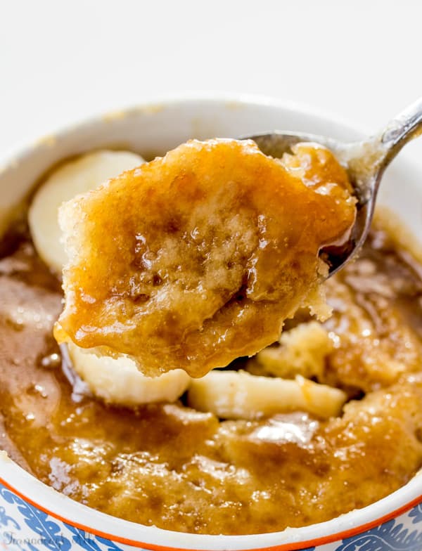 Spoon pulling out portion of mug cake showing caramel glaze