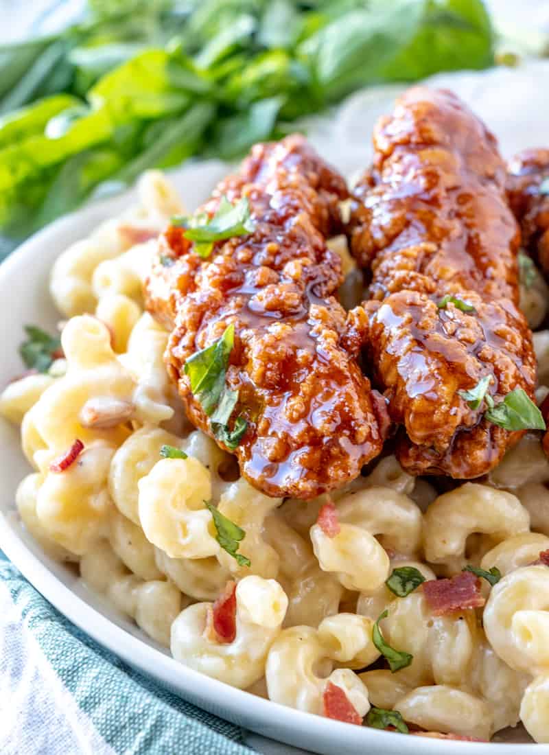 Chicken Mac in cheese in white serving bowl with parsley in background