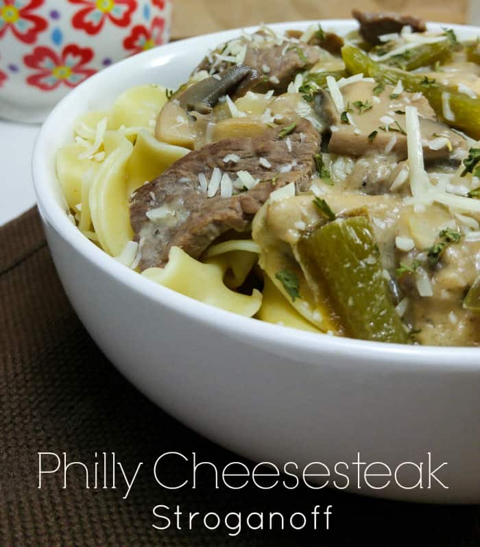 Philly Cheesesteak Stroganoff in white bowl topped with shredded cheese
