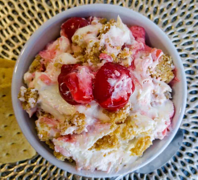 Overhead of Cherry Cheesecake Fluff in bowl topped with cherries and crushed graham crackers