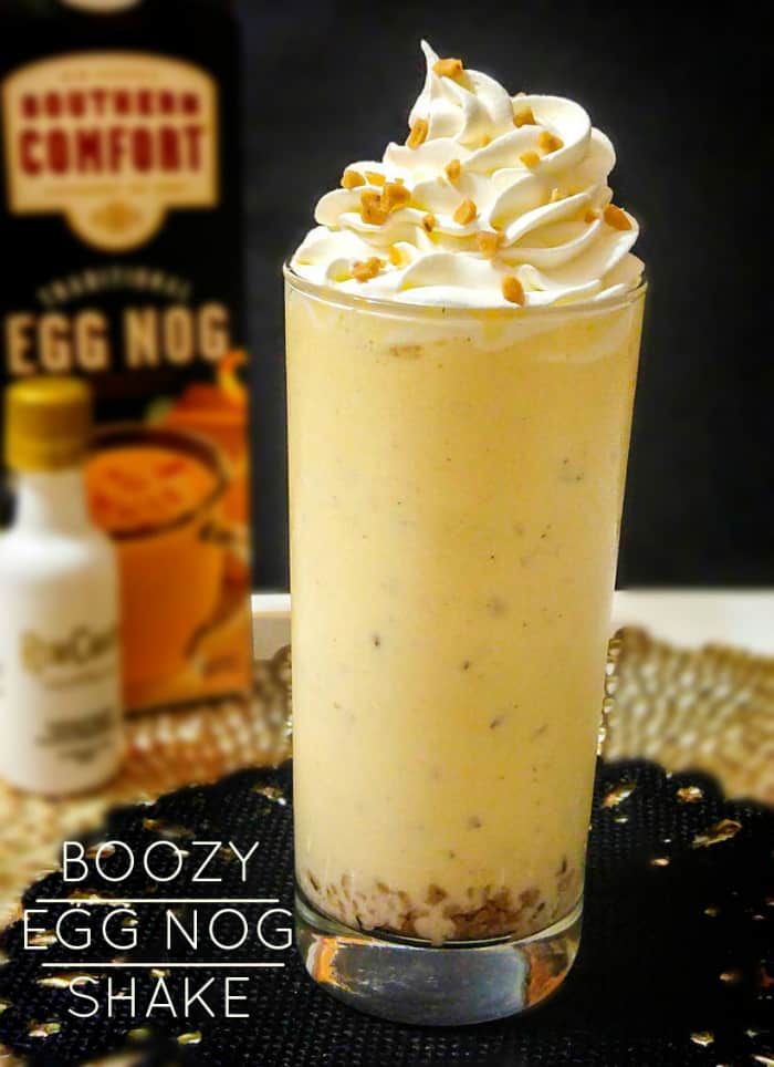 Tall Glass of Boozy Egg Nog topped with whipped cream and toffee bits