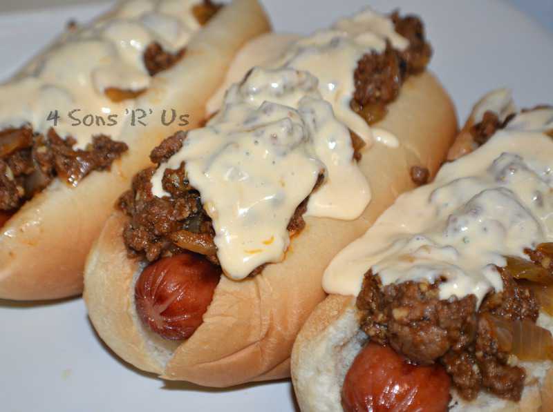 Three Cheesy Sloppy Dogs on white plate topped with garlic cheese sauce