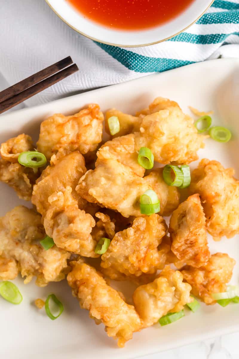 overhead photo of crispy Chinese chicken on plate with green onions on top