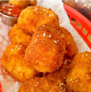 Cheesy Tater Tots in red bar basket topped with sea salt