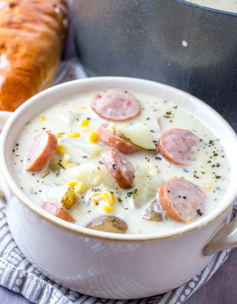 Chowder spooned into white handled bowl 