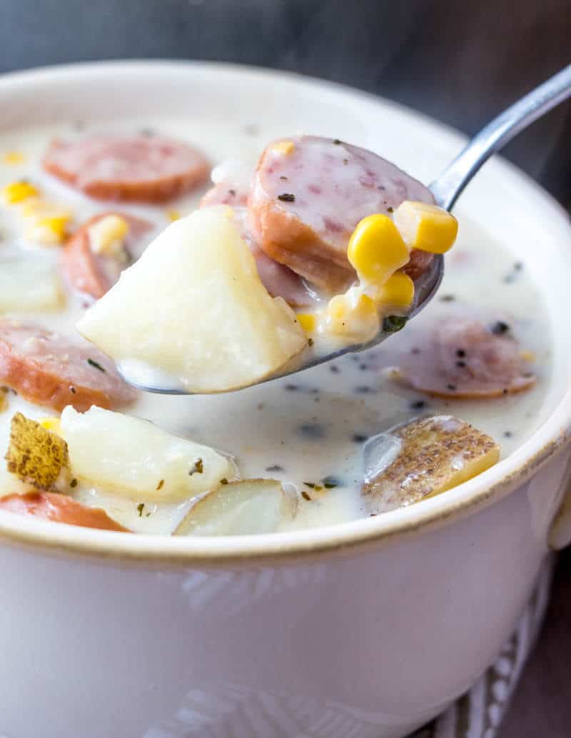 Spoon holding some of chowder out of bowl