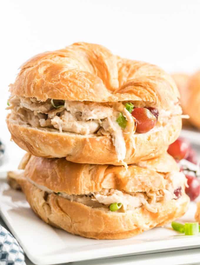 Two chicken salad sandwiches in croissants stacked not op of on another