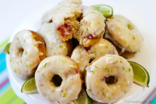 Strawberry Lime Donuts on cake stand with sliced limes