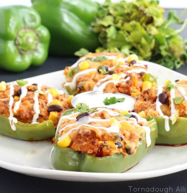 Plate of four Chorizo Stuffed Peppers drizzled with sauce