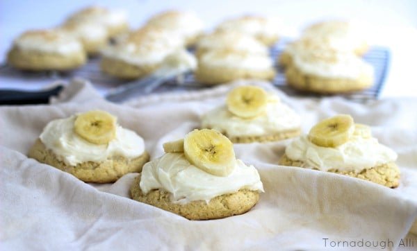 Cookies on white linen frosted and topped with sliced bananas