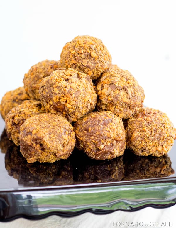 Stacked Butterfinger Donut Holes on black cake stand