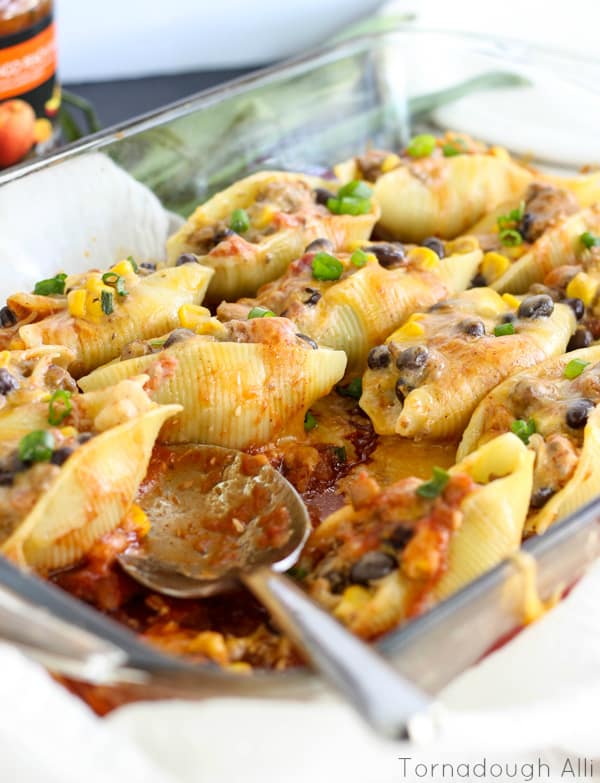 Serving spoon in baking dish with some shells removed