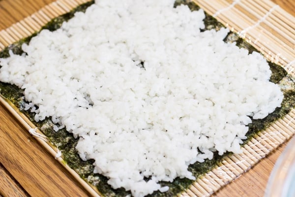 Rice on seaweed on sushi roller