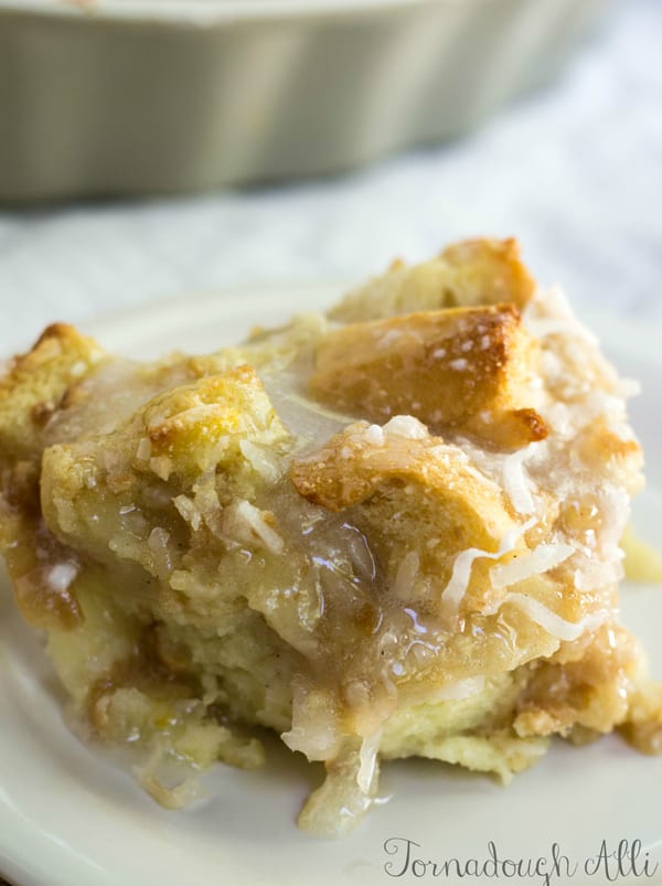 Slice of Coconut Cream Bread Pudding on plate with glaze