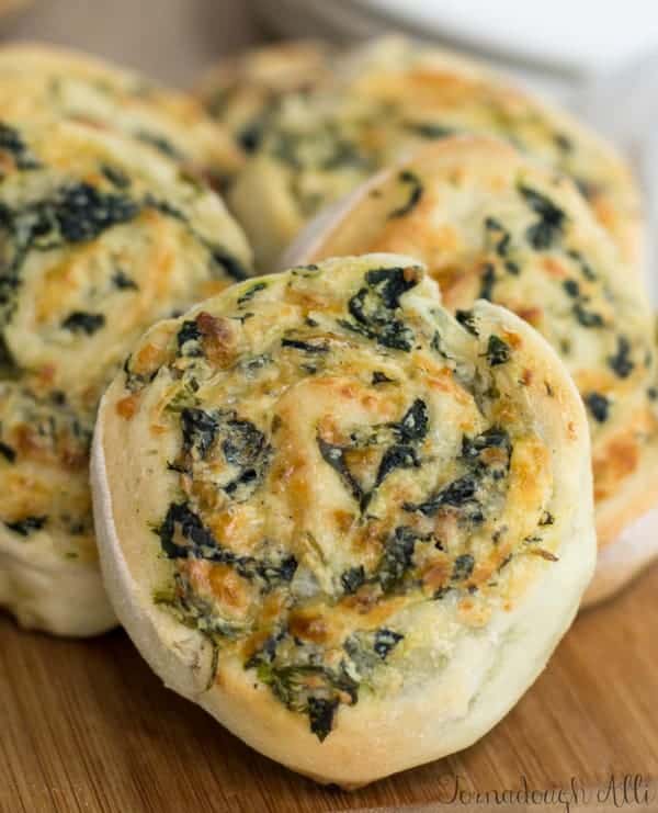 Spinach Dip Pinwheels layered on one another on cutting board