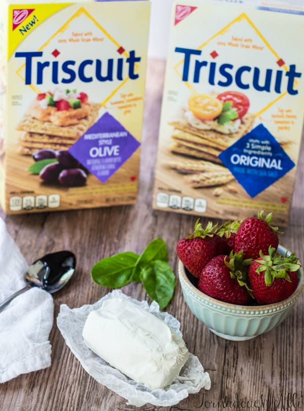 Two boxes of Triscuit Crackers, strawberries, basil and cheese