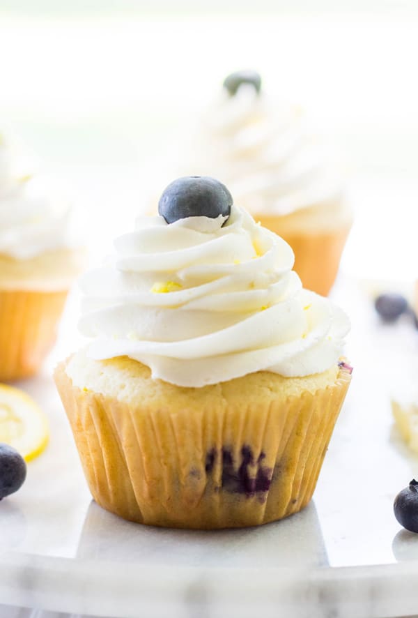 Cheesecake Stuffed Lemon Blueberry Cupcake close up on platter topped with blueberry