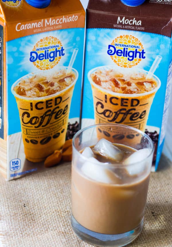 Glaze of iced coffee in front of containers of International Delight Caramel Macchiato and Moca