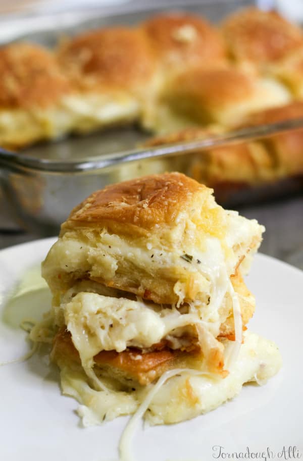 Stacked Cheesy Stuffed Garlic Bread Sliders on white plate