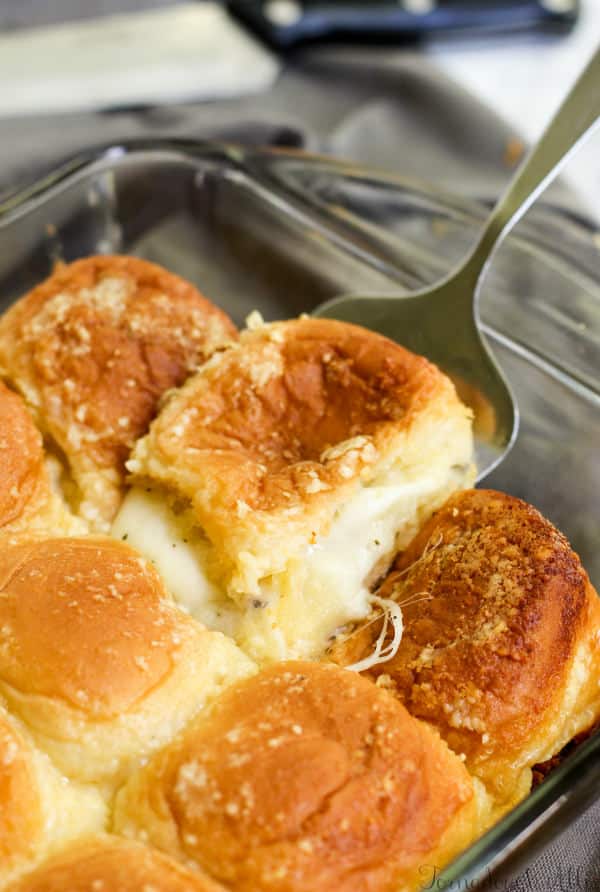 Cheesy Stuffed Garlic Bread Sliders being pulled out with serving spatula