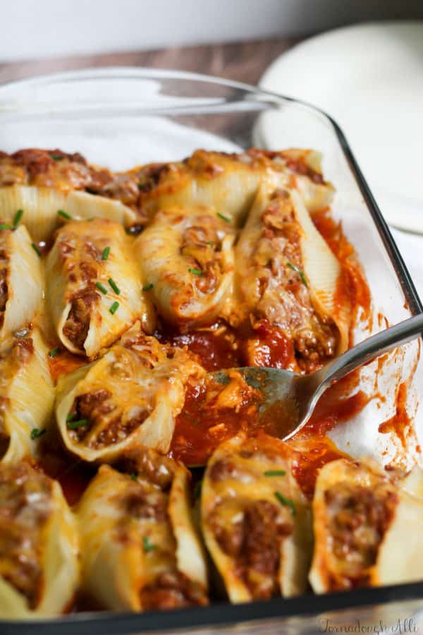Sloppy Joe Stuffed Shells being spooned out of baking dish