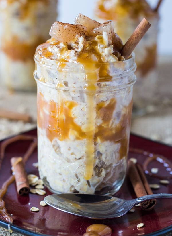 Caramel Apple Pie Overnight Oats on red plate with caramel dripping down side of jar