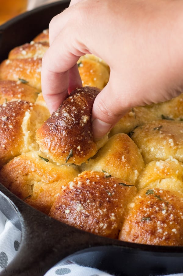 Hand pulling piece of Monkey Bread out of pan