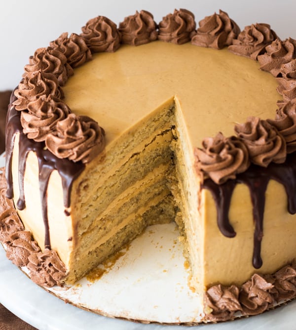 Peanut Butter Banana Cake with Whipped Ganache on turntable with slice taken out