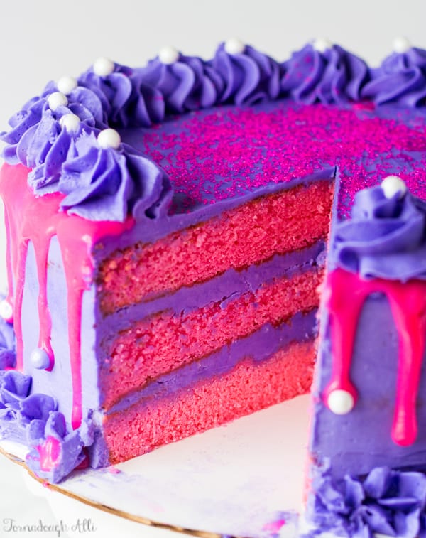 Pink Velvet Cake with Purple Vanilla Buttercream with slice missing showing inside of cake