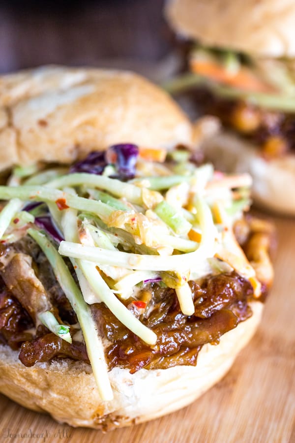 Close up of one Asian BBQ Pork Sliders with Kimchi Slaw on wooden board