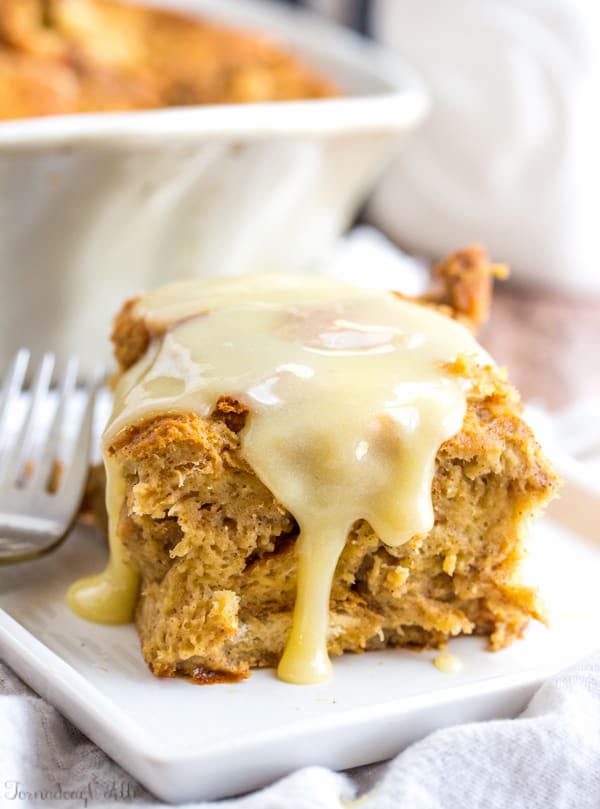 Gingerbread Bread Pudding on white plate with sauce dripping down