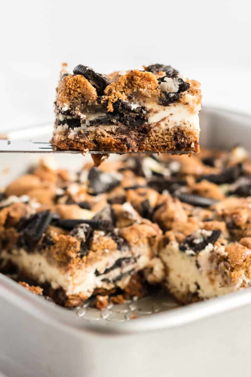 Oreo Chocolate Chip Cheesecake Bar on serving spatula coming out of pan