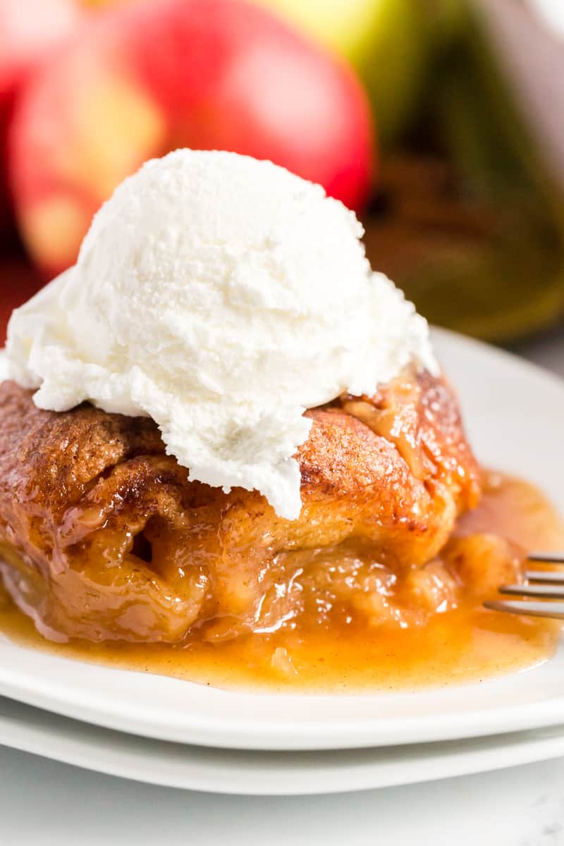 Apple Dumplings on plate with ice cream on top and apples in background