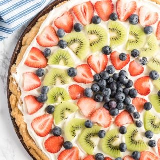 overhead of finished fruit pizza topped with strawberries, blueberries and kiwi