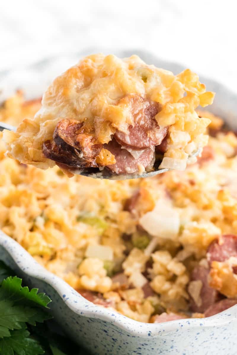 Smoked Sausage Cheesy Potatoes on serving spoon coming out of casserole dish