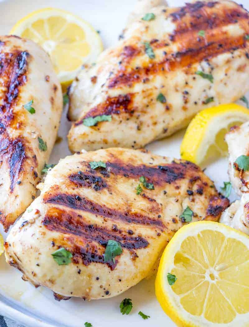 Lemon Pepper Chicken in white platter with lemons and parsley