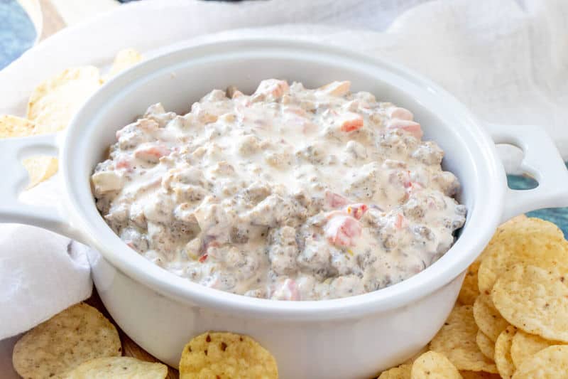 horizontal photo of sausage dip in serving dish with chips