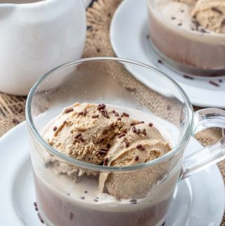 Affogato in clear glass on white plate topped with sprinkles
