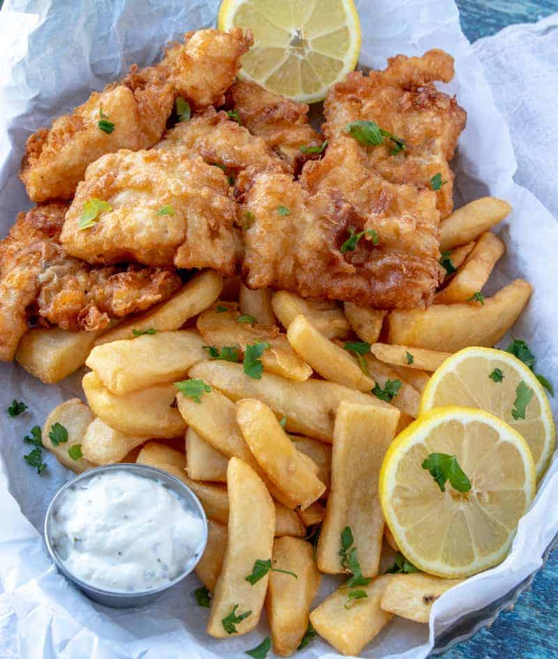 Fish and chips on tray with lemons and tartar sauce overhead