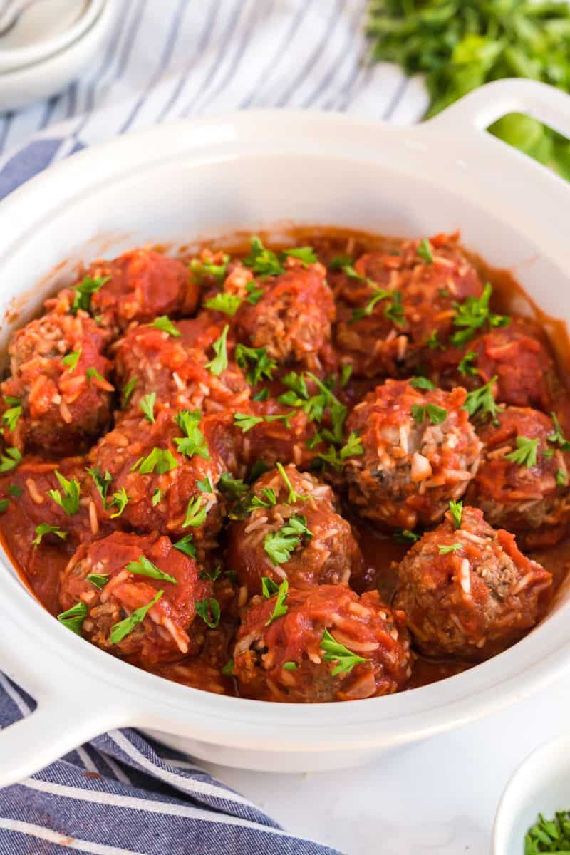 Side view of finished baked meatballs topped with parsley